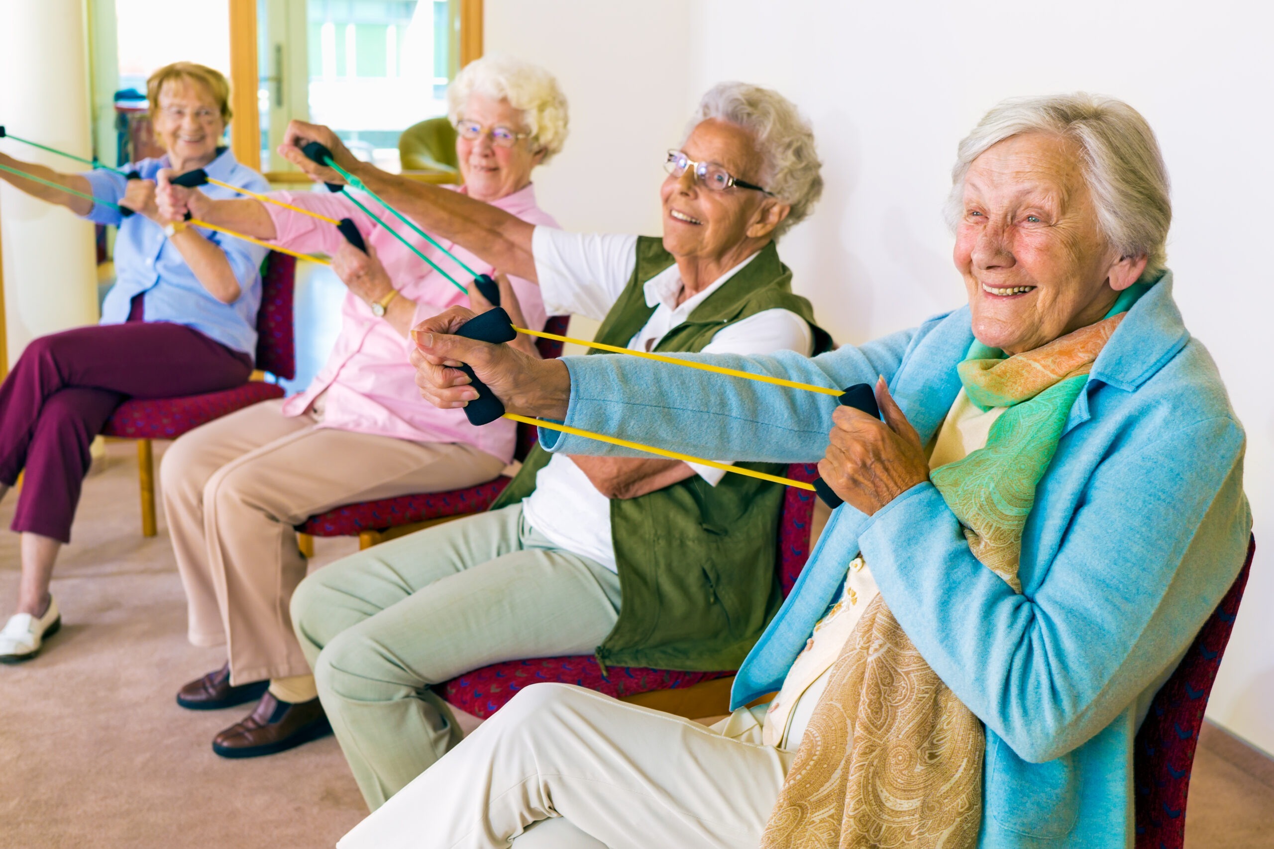 Cheerful senior women exercising their arms. Senioren Tagesbetreuung